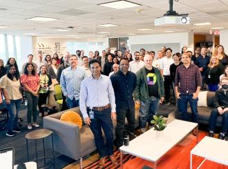 employees pose for a group photo after a presentation